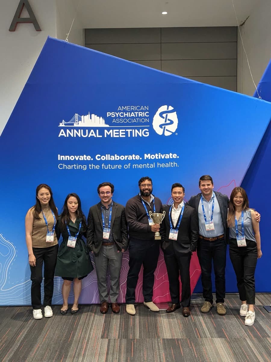 Ambience Healthcare team at APA Annual Meeting with award trophy