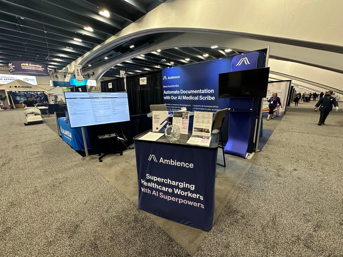 Ambience Healthcare booth at conference with 'AI Superpowers' signage